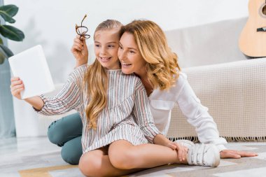 Büyükanne ve torunu evde dijital tablet ile görüntülü görüşme yapmayı gülüyor