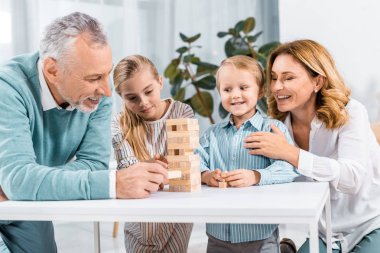 dedesi ve blok ahşap kule oyun birlikte evde oynarken torun gülümseyen