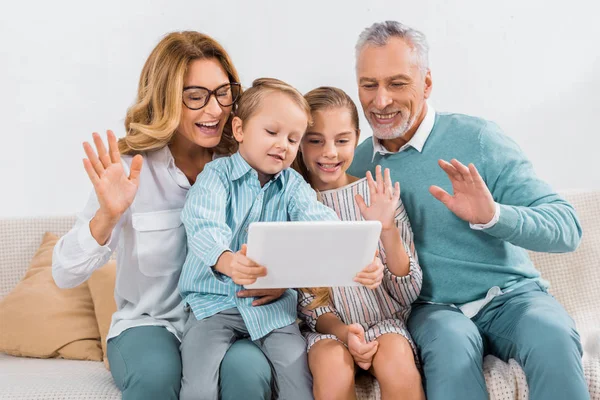 孙子和爷爷奶奶挥手致意 而有视频通话与数字平板电脑在家里 — 图库照片