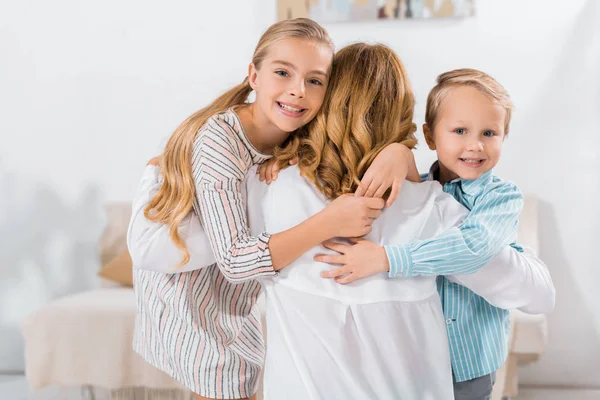 Niños Sonrientes Mirando Cámara Abrazando Abuela Casa —  Fotos de Stock