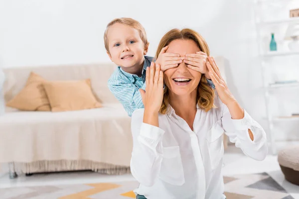 Smiling Little Boy Looking Camera Covering Eyes Smiling Grandmother Home — Free Stock Photo