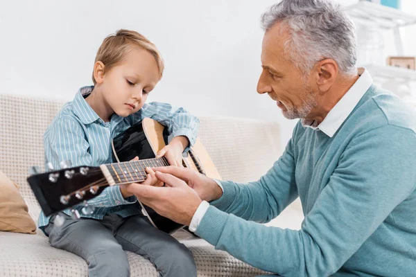 Widok Boku Bliskiego Wieku Człowiek Uczy Wnuka Gra Gitarze Akustycznej — Zdjęcie stockowe