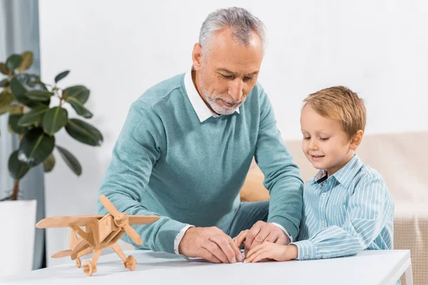 Mature Man Making Paper Plane While His Adorable Grandson Sitting — Stock Photo, Image
