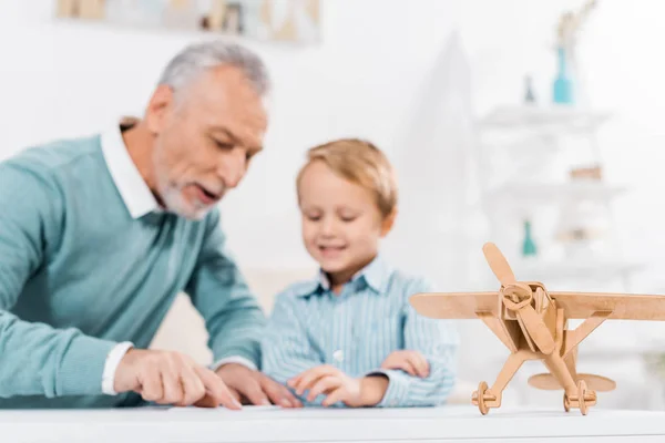 Selective Focus Mature Man Making Paper Plane While His Adorable — Stock Photo, Image