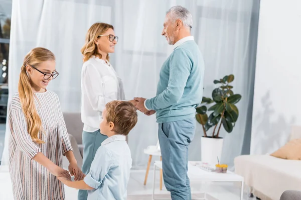 Smiling Kids Holdings Hands Each Other While Grandparents Standing Home — Stock Photo, Image
