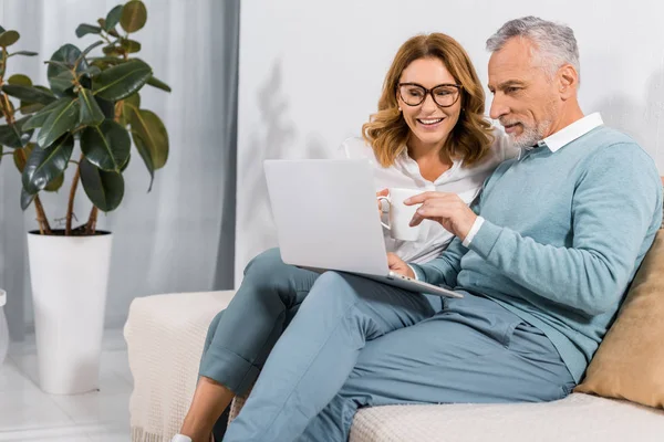 Handsome Mature Man Pointing Hand Laptop Screen Beautiful Wife Sofa — Stock Photo, Image