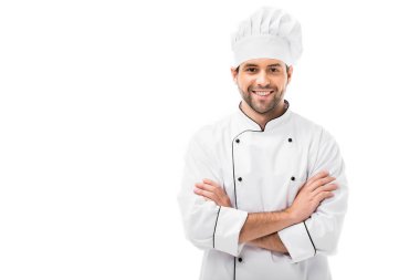 smiling young chef with crossed arms looking at camera isolated on white clipart