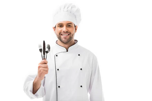 Uśmiechnięty Młody Szef Kuchni Trzymając Kilka Sztućców Białym Tle — Zdjęcie stockowe