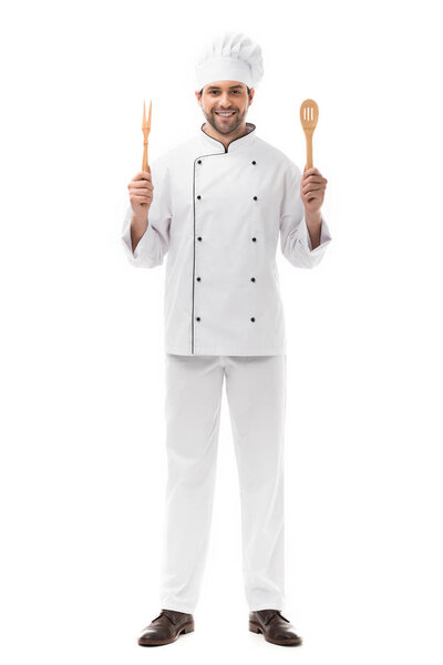 улыбающийся молодой шеф-повар, держащий кухонную утварь и смотрящий на камеру, изолированную на белом
