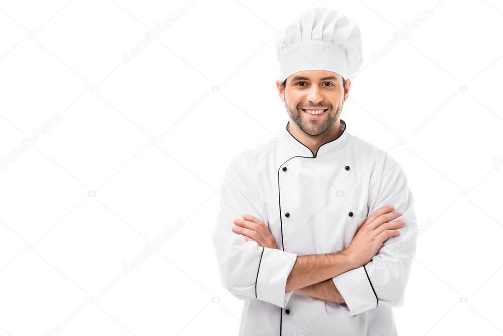smiling young chef with crossed arms looking at camera isolated on white