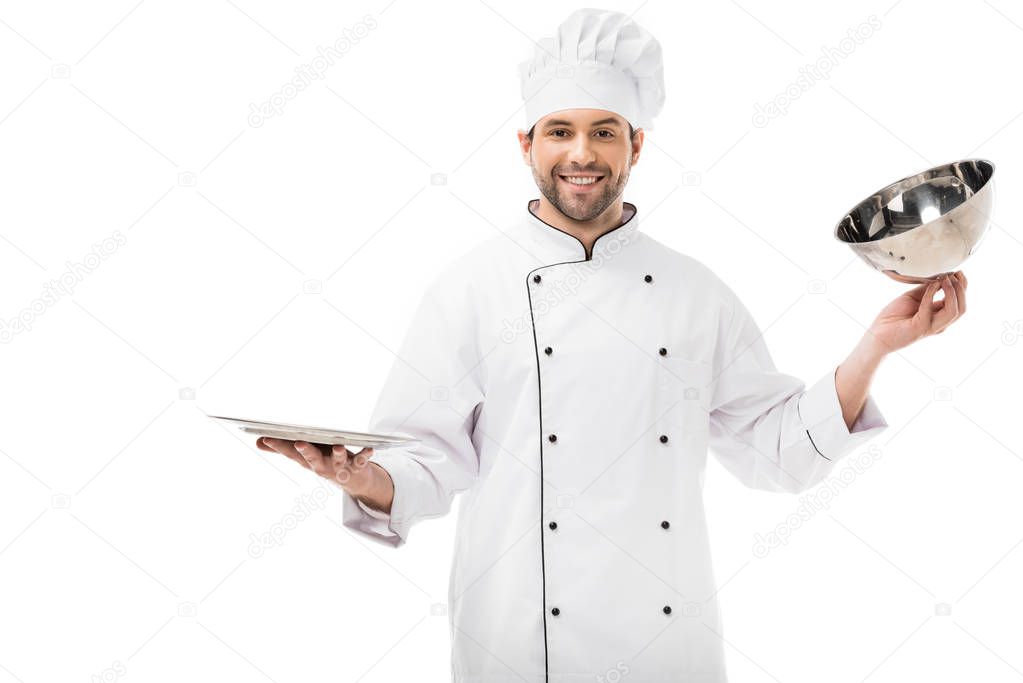 handsome young chef taking of serving dome from plate isolated on white