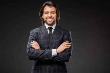 çapraz kolları ile duran ve üzerinde siyah izole kamera gülümseyen yakışıklı mutlu işadamı