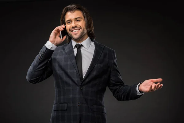 Sonriente Joven Hombre Negocios Hablando Por Teléfono Inteligente Aislado Negro — Foto de stock gratuita