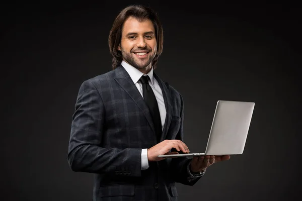 Jovem Empresário Bonito Usando Laptop Sorrindo Para Câmera Isolada Preto — Fotografia de Stock