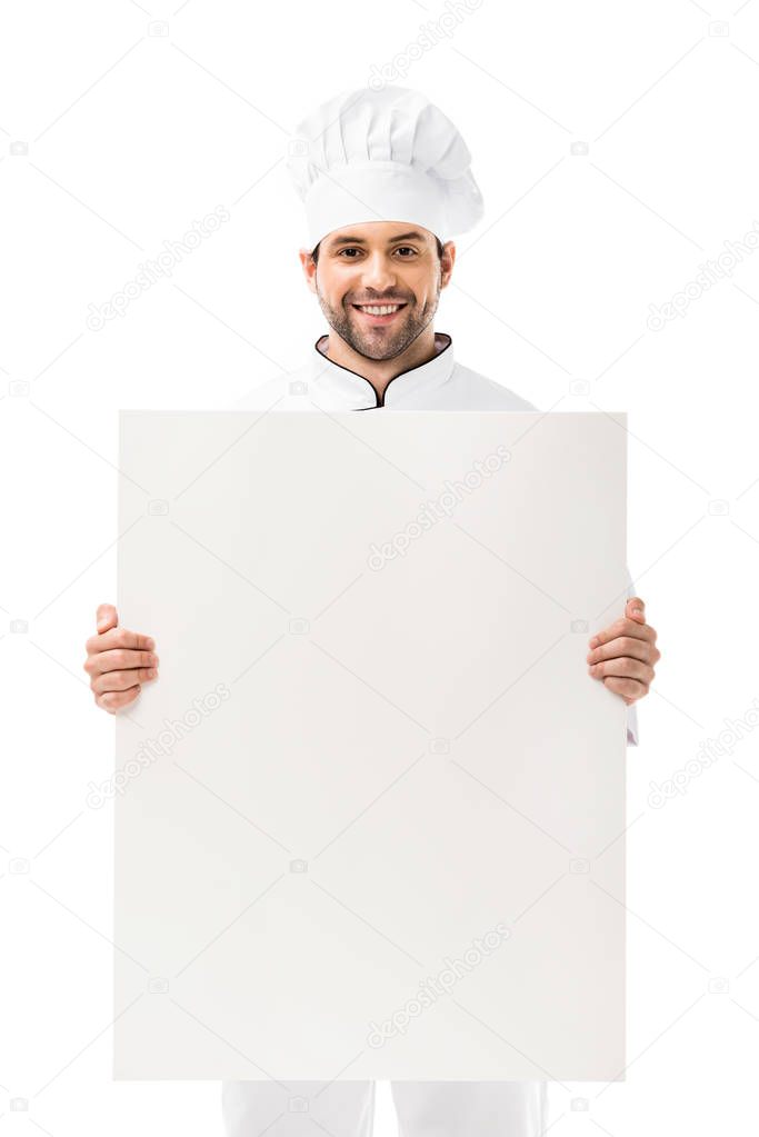 professional young chef holding blank placard and smiling at camera isolated on white  