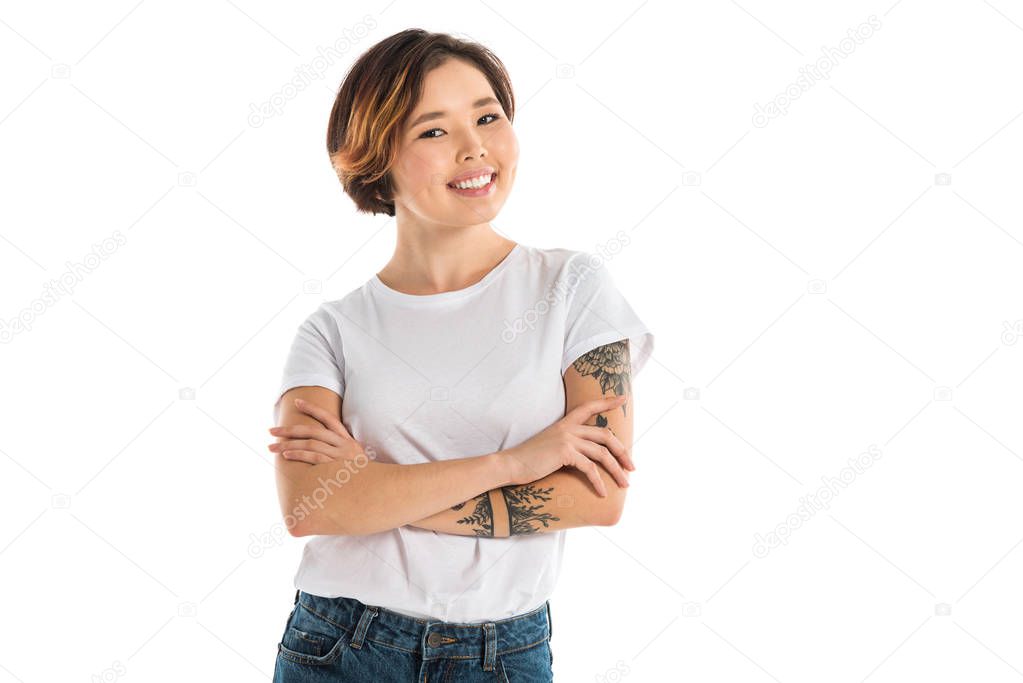 young woman with arms crossed looking at camera and smiling isolated on white