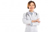 Lächelnde Ärztin mit Stethoskop und Armkreuzen, die isoliert auf weiß in die Kamera blickt