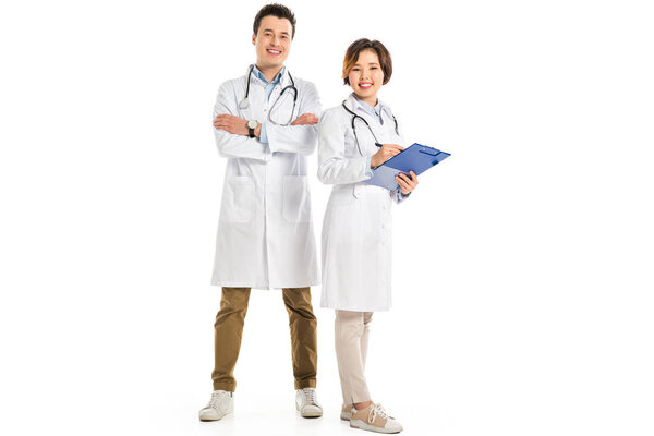 female doctor holding diagnosis and male doctor with crossed arms looking at camera isolated on white