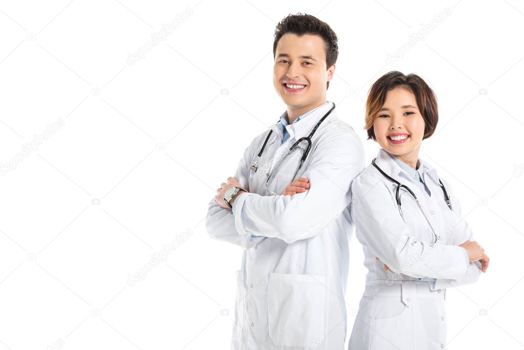 female doctor and male doctor with crossed arms looking at camera and smiling isolated on white