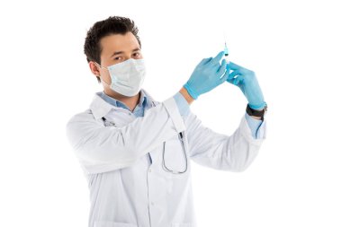 Lastik eldiven ve şırınga tutarak ve üzerinde beyaz izole kamera bakarak maskesi erkek doktor odaklı