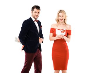 Yakışıklı adam arkasında çiçek tutarken geri güzel kadın okuma kartpostal beyaz izole