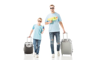 Dad and son walking with luggage and holding water guns isolated on white clipart