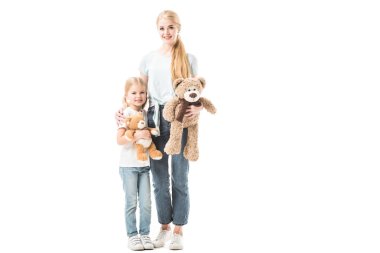 Anne ve kızı ayakta ve oyuncak ayılar üzerinde beyaz izole holding