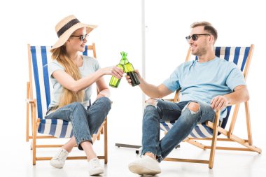 Couple sitting on deck chairs, relaxing and drinking beer isolated on white clipart