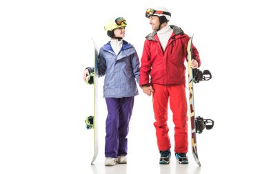 Çift snowboards tutarak ve birbirine bakarak beyaz izole Kayak elbiseli gülümseyen