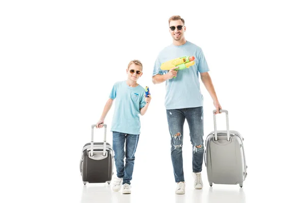 Μπαμπάς Και Γιος Περπάτημα Αποσκευές Και Κρατάτε Νεροπίστολα Απομονωθεί Λευκό — Φωτογραφία Αρχείου