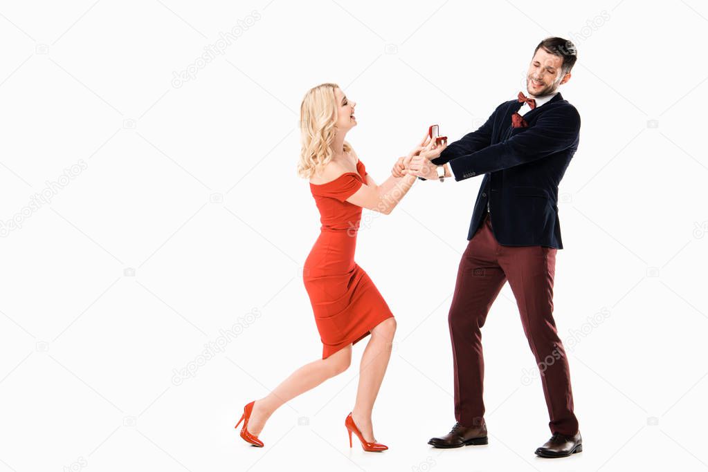 Attractive woman proposing boyfriend with ring isolated on white