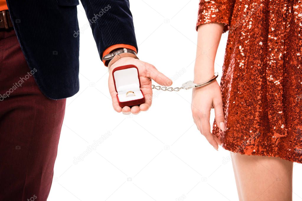 Partial view of couple in handcuffs and man holding ring box isolated on white