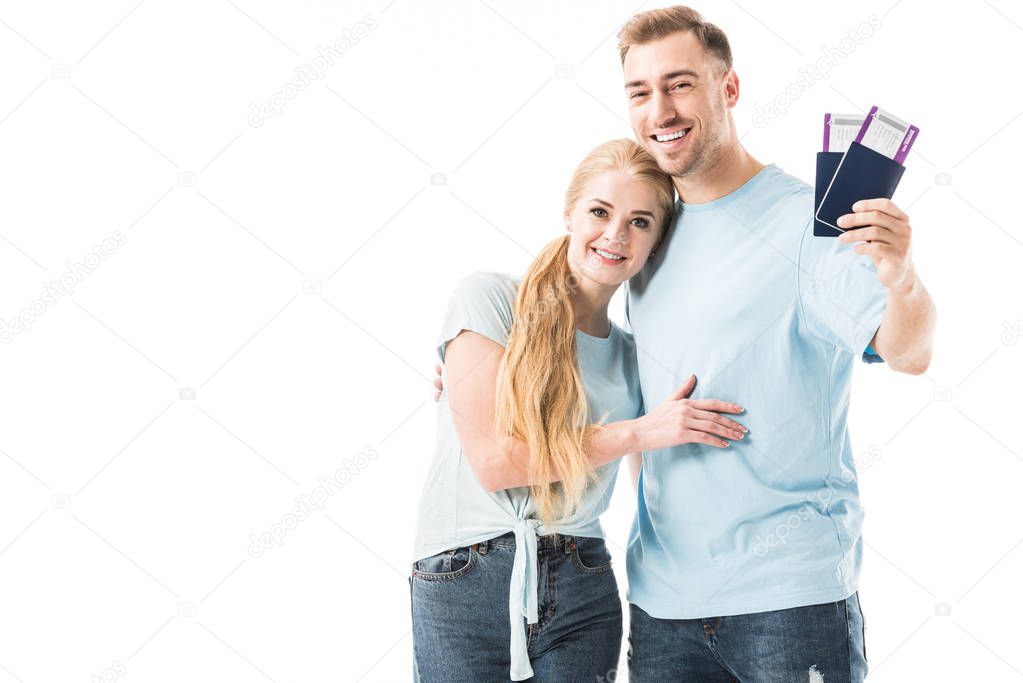 Couple standing with passports and smiling isolated on white 