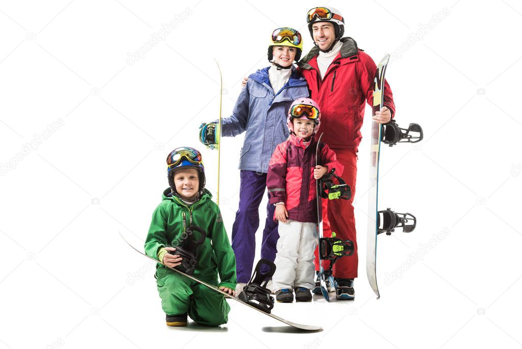 Cheerful family standing in snowsuits with snowboards and smiling isolated on white