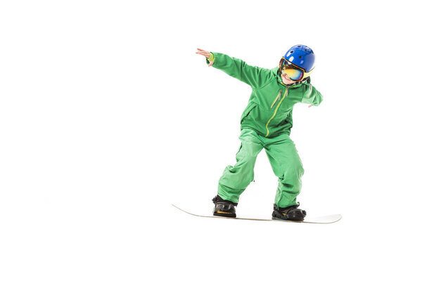 preteen boy in green ski suit, goggles and blue helmet snowboarding isolated on white