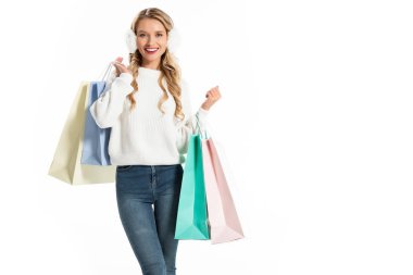 cheerful woman in winter outfit holding shopping bags isolated on white clipart