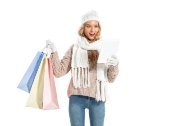 excited woman with shopping bags using digital tablet isolated on white clipart
