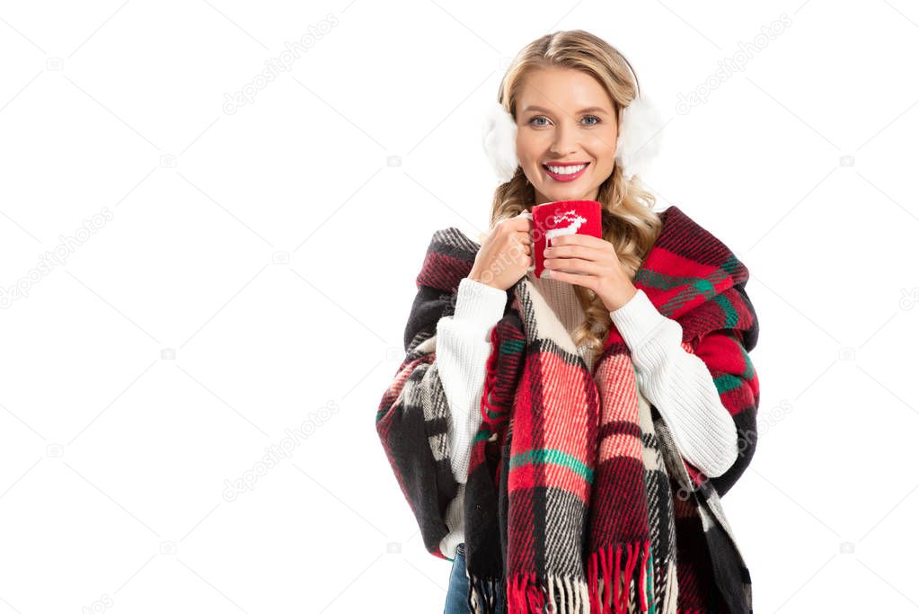 beautiful smiling woman in warm blanket holding cup of coffee isolated on white