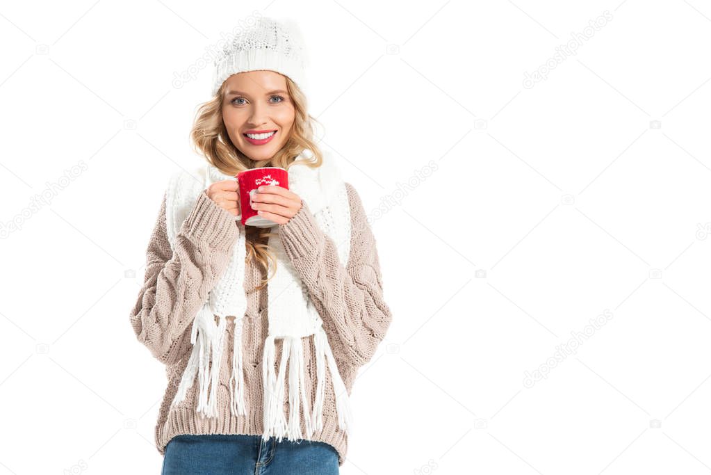 beautiful smiling woman in winter outfit holding cup with hot drink isolated on white