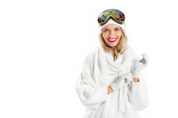 Nice young woman in warm clothes and ski goggles wearing  mittens isolated on white