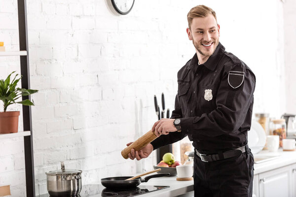police officer smiling and cooking breakfast at kitchen