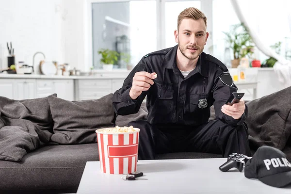 Policjant Siedzi Kanapie Jedzenie Popcorn Oglądając Film — Zdjęcie stockowe