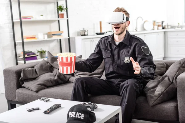 Policier Avec Casque Réalité Virtuelle Sur Tête Tenant Seau Maïs — Photo gratuite