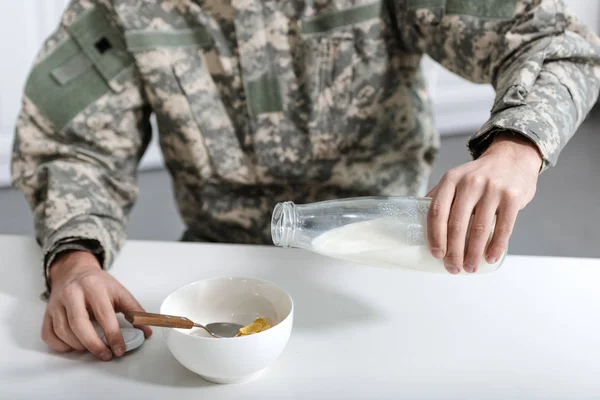 Vista Ritagliata Dell Uomo Militare Versando Latte Ciotola Con Fiocchi — Foto Stock