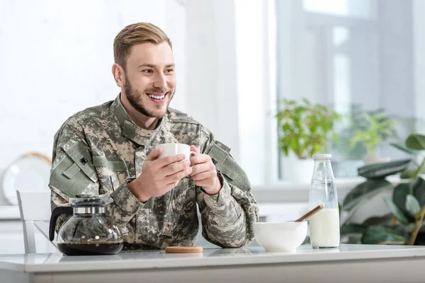 Bonito Homem Uniforme Militar Sorrindo Bebendo Café Mesa Cozinha — Fotografia de Stock