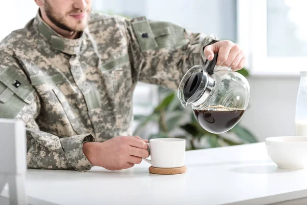 Recortado Vista Del Hombre Camuflaje Uniforme Verter Café Taza Cocina — Foto de stock gratis