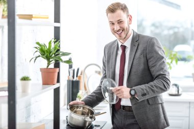 pot holding ve mutfakta yemek hazırlanıyor formal giyim gülümseyen işadamı