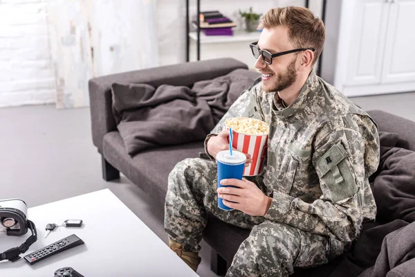 微笑的陆军士兵在3D 眼镜在沙发上看电影爆米花和苏打水 — 免费的图库照片