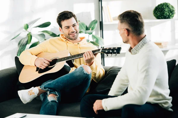 Lachende Zoon Spelen Van Akoestische Gitaar Voor Volwassen Vader Weekend — Stockfoto