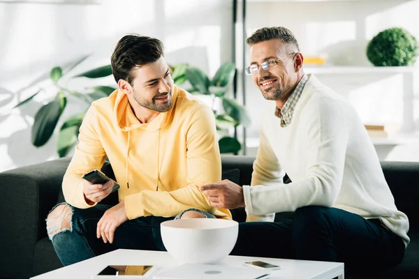 oğlu ve olgun baba birlikte hafta sonu evde televizyonun gülümseyen